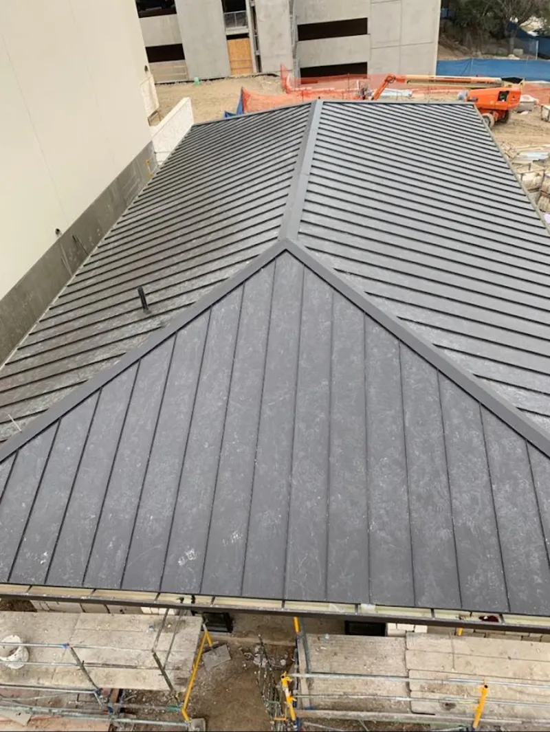 Commercial metal roof construction with crane equipment in Short Pump